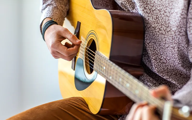 Hands playing acoustic guitar